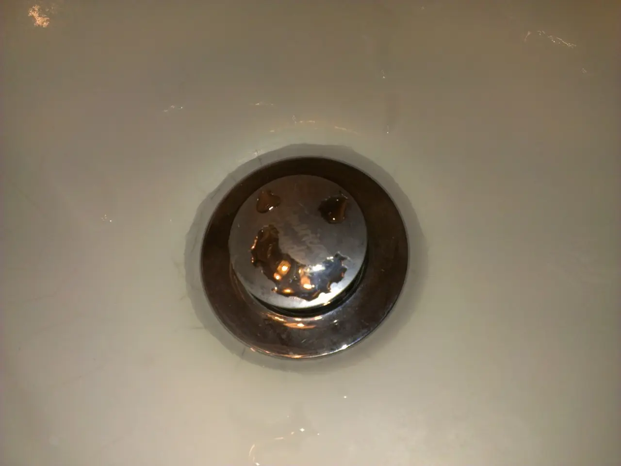 There is a sink with drain. On that there is water.