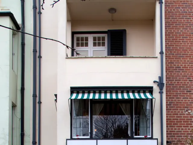 This picture shows about the beautiful small house with glass balcony and window. In front we can...