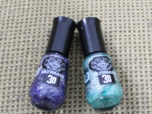 In this image we can see a pair of nail polish placed on the cloth.