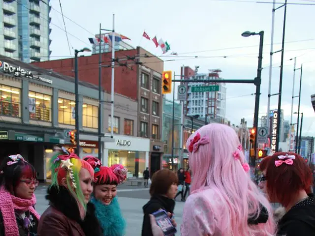 In this image we can see six women are standing, one woman is wearing pink color jacket with black...