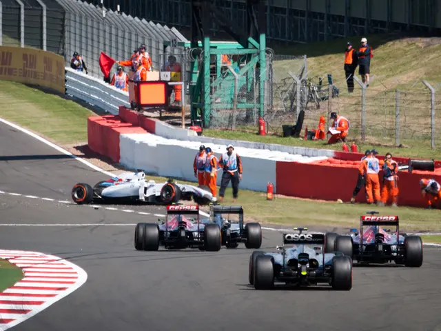 Vehicles are on the road. Here we can see people, fence, grass and hoarding.